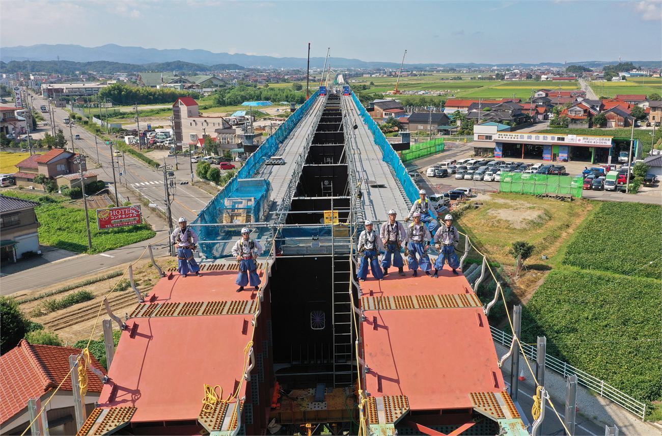 北陸新幹線の建設中の高架橋の上に立つ作業員の空撮